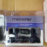 Front view of MECHUNIK wheel lock set packaging showing bolts and key through clear plastic with branding.