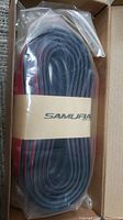 Box containing coiled black rubber skirt guard with red edges, sealed in plastic with Samurai branding.