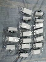 Seventeen new sealed white rocker switches arranged for viewing, showing the front switch plate and mounting frames.