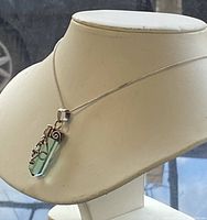 Front view of necklace on display bust showing turquoise pendant and silver chain