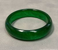 Front view of green jade bangle showing polished surface and rich green color.