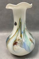 Front side view of 7.5 inch Murano art glass vase showing multicolored swirled pattern and scalloped rim.