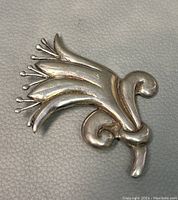 Front view of sterling silver floral design brooch showing details of petals and stamens.