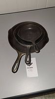 Top view of three nested cast iron pans showing size markings 3, 5, and 8 on handles