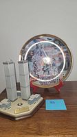 View of Twin Towers model and commemorative plate on wooden surface
