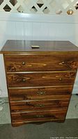 Photo of dark wood dresser showing the full front with five drawers and the top surface.