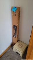 Vintage Kodak slide projector and boxed projection screen next to wall