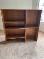 Photo shows a teak wood Mid-Century Modern hutch top shelving unit with multiple open shelves arranged asymmetrically.