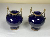 Front view of both urns side by side on white surface