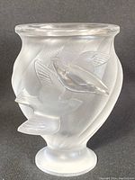 Front view showing two overlapping dove appliqués on fluted vase
