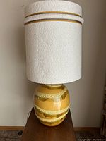 Front view of the full lamp showing ceramic base and large 20-inch shade