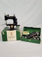 Full lot overview: Sewhandy machine on original box with green template case open