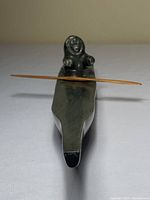 Front view of the soapstone sea kayak carving showing the kayaker figure and wooden paddle.