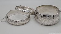 Three sterling silver hinged bangle bracelets arranged side by side
