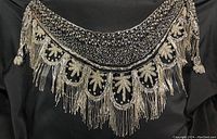 Full view of the vintage beaded shawl showing detailed beadwork, scalloped edges, and tassels.