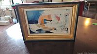 Image of small framed abstract painting on board, showing the mix of colors and signature.