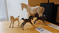 All four horse figurines grouped on tabletop with lot stickers visible