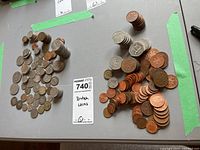 Assortment of British coins scattered and stacked on a table with a MaxSold lot tag indicating 'British Coins'.