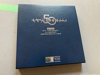 Navy blue keepsake presentation box with gold embossed text commemorating 50th anniversary of D-Day silver proof issue, Royal Mint logo at bottom.