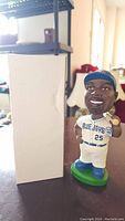 Bobblehead of Carlos Delgado standing next to the original plain white box