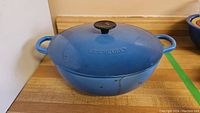 Blue Dutch oven with lid on, front view showing Le Creuset logo stamp