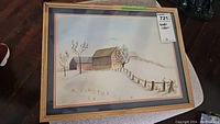 Framed watercolor landscape painting showing barn, fence, and leafless trees in a muted landscape with natural wood frame and glass.
