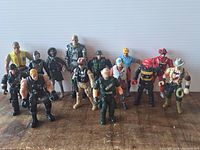 Wide view showing all 13 action figures arranged in rows on a wood table surface