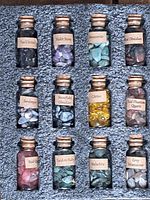 Top view showing all twelve labeled bottles of gemstones arranged in foam holder.