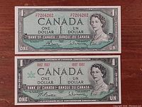 Front view of 1954 and 1967 Canadian one-dollar bills showing front design with Queen Elizabeth II portrait and serial numbers.