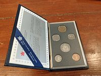 Complete 1990 Canadian coin set displayed in blue official Royal Canadian Mint presentation case, showing all coins and informational insert.
