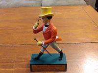 Full view of Johnnie Walker striding man bar display figurine on wooden table.
