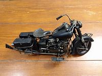 Side angle view of the detailed metal motorcycle model showing overall shape, saddlebags, seat, and frame details.