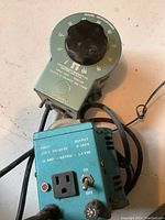 Photo of two variable auto transformers showing dial, outlet, toggle switch, and labels