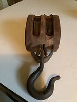 Front top view of the vintage wooden pulley showing wooden double sheave and metal hook