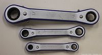 Photo of three reversible ratcheting metric wrenches arranged on a surface showing sizes 17 and 15, 11 and 10, 8 and 6 millimeters.