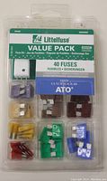 Front view of Littelfuse 40 piece fuse set with assorted ATO blade fuses in color-coded slots and included fuse puller-tester.