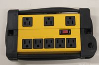 Top view of Husky 8 outlet power bar showing all 8 outlets, red reset/power switch, and cord wrapped around base.