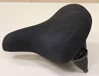 Side view of black bicycle saddle showing curved padded seat.