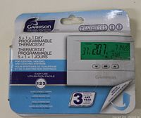 Front view of Garrison 5+1+1 Day Programmable Thermostat in original packaging showing the digital display and product features.