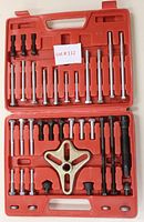 Full view of the gear puller set inside the red plastic molded case, showing top and bottom components organized on case inserts.