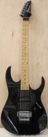 Full view of black Ibanez RG series electric guitar with maple neck and fretboard, black body, six strings, and black headstock with chrome tuning pegs.