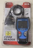Front of INNOVA 3030 code reader in original plastic packaging showing device with connector cable, labelled as Level 2 code reader for reading and clearing check engine lights.