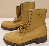 Side angled view of both light brown/tan steel toe work boots showing leather uppers and brown soles.