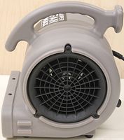 Front view of the gray Lasko Super Fan Max showing air intake grill and handle with branding label.