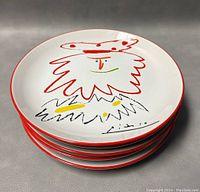 Stack of five Picasso 'The King' plates showing profile and thickness with red rim and colorful design.