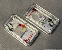 Pair of boxed Chinese 999 silver miniature bars, one with fish and one with star designs.