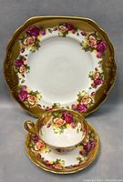 Full view of teacup set with square cake plate showing floral patterns and gold accents