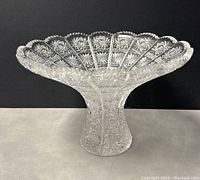 Front angle view of vintage Bohemian cut crystal vase showing sawtooth scalloped rim and cut starburst patterns.