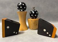 Front view of vintage salt shaker and pepper grinder with two wooden domino-style candleholders