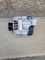 Side view showing alternator pulley and copper windings inside ventilation slots.